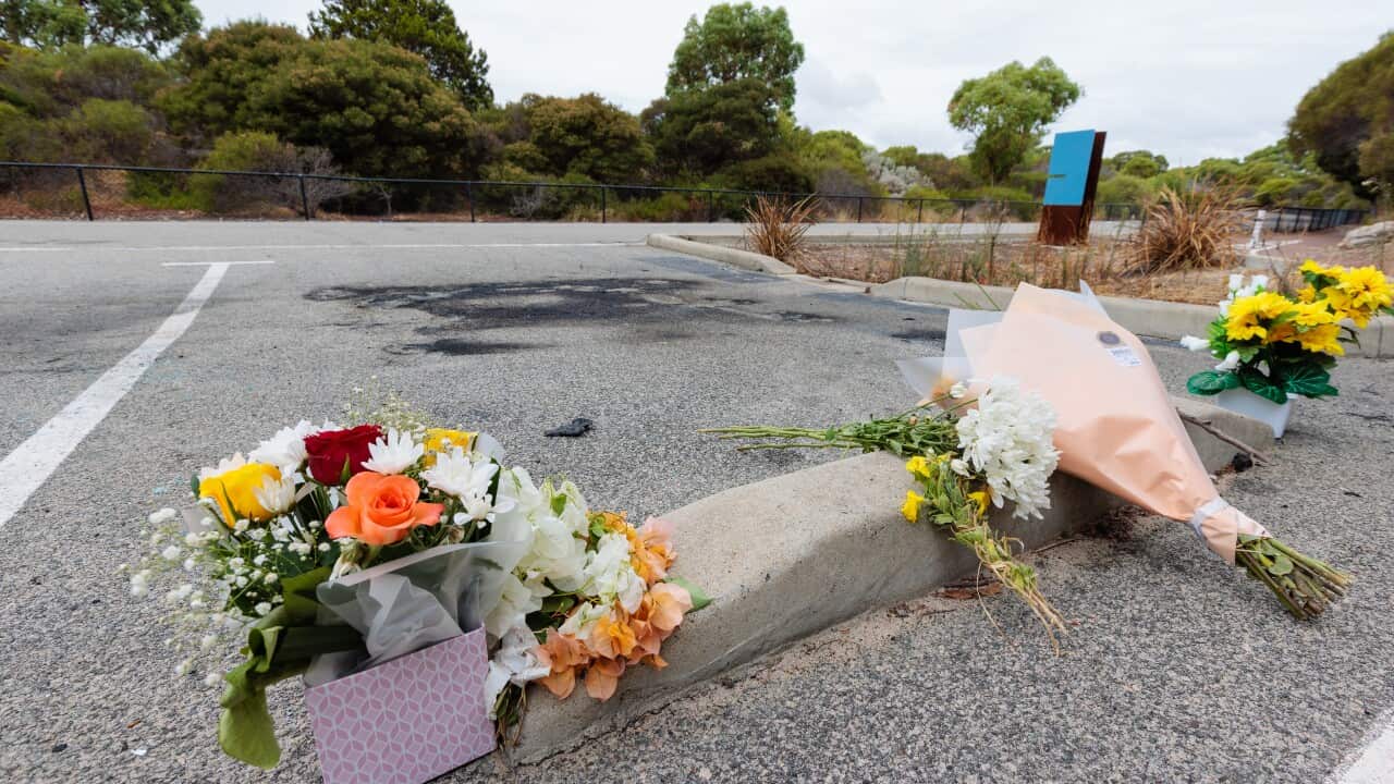 Flowers and a scorched car parking bay are seen at the scene of a fatal car fire in Coogee, Western Australia