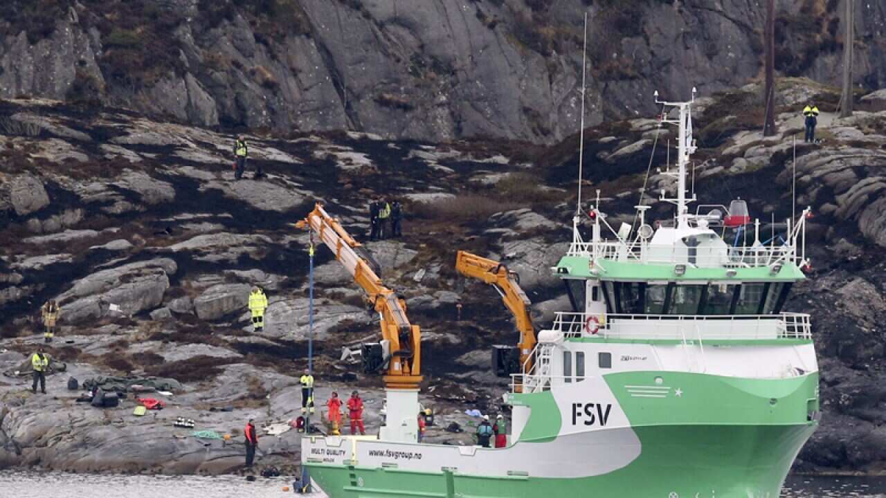 A rescue vessel lifts up parts of a helicopter, Norway
