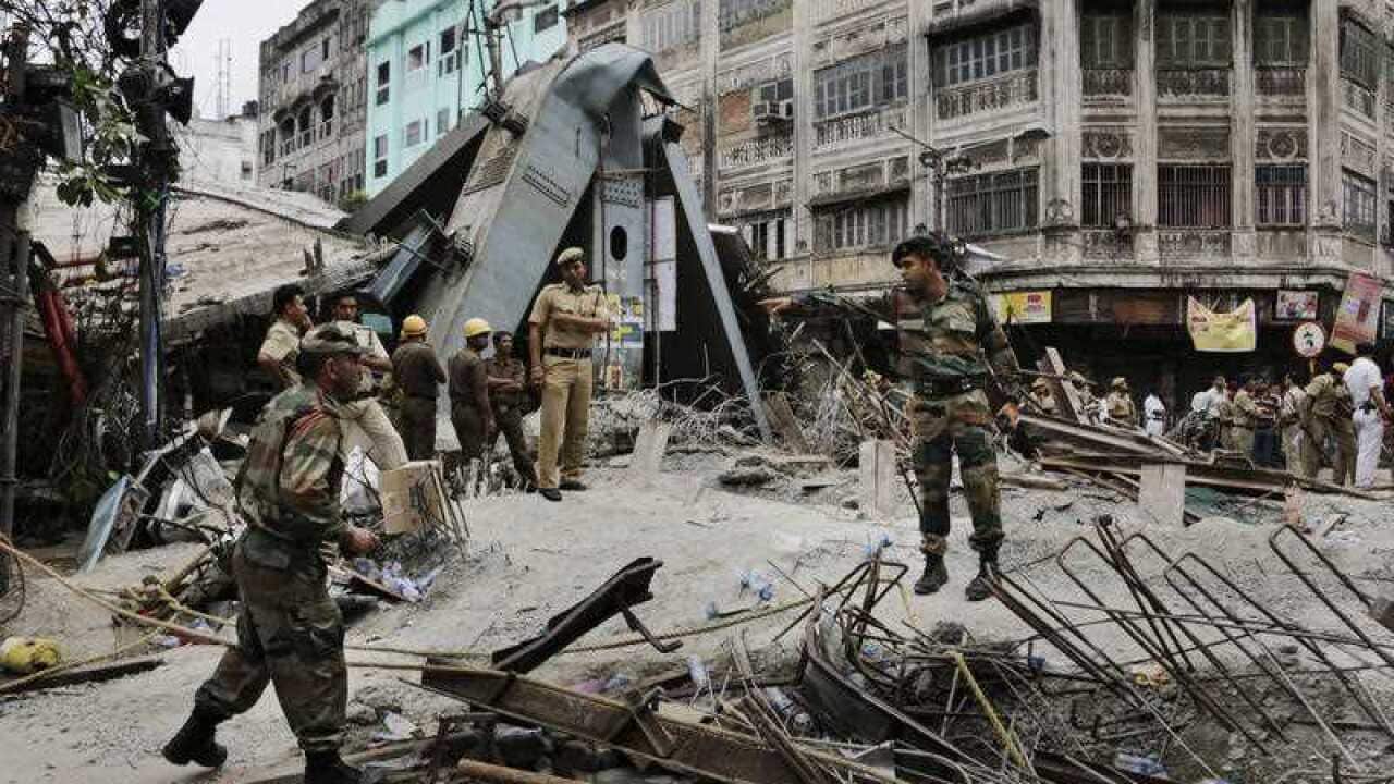 Security officers work on the area of a collapsed overpass in Kolkata, India.
