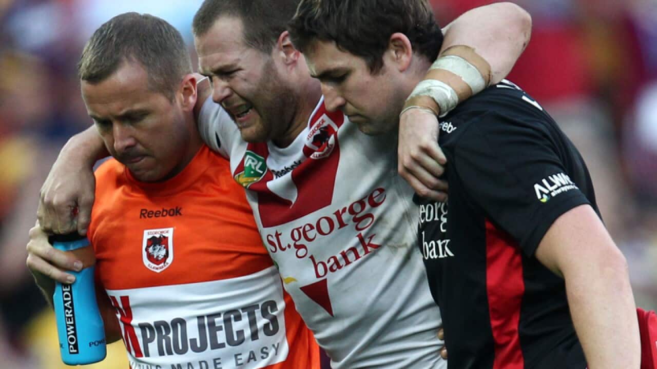 Cannonball tackle victim Trent Merrin (C) is carried from the field
