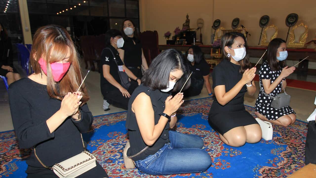 People wearing face masks attend a funeral ceremony of a Thai man aged 35 who was suffering from dengue fever and later got infected with Covid-19. (Photo by Adisorn Chabsugnoen / SOPA Images/Sipa USA)