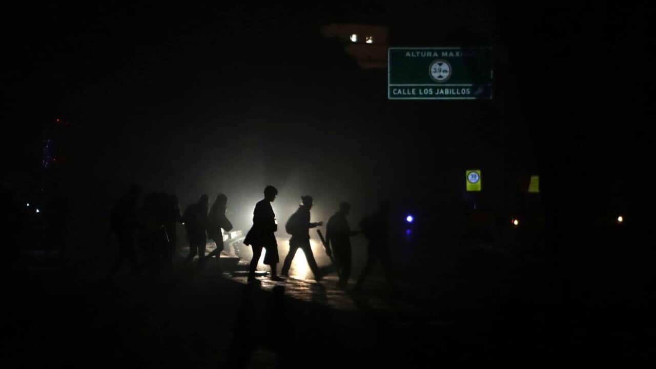 People walk in a street in the dark during a power outage in Caracas, Venezuela.