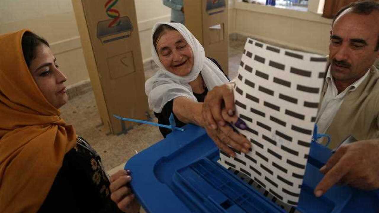 A Kurdish woman in traditional clothes casts her ballot during the Kurdistan parliamentary election at a polling station in Erbil, the capital of the Kurdistan Region in Iraq, 30 September 2018.