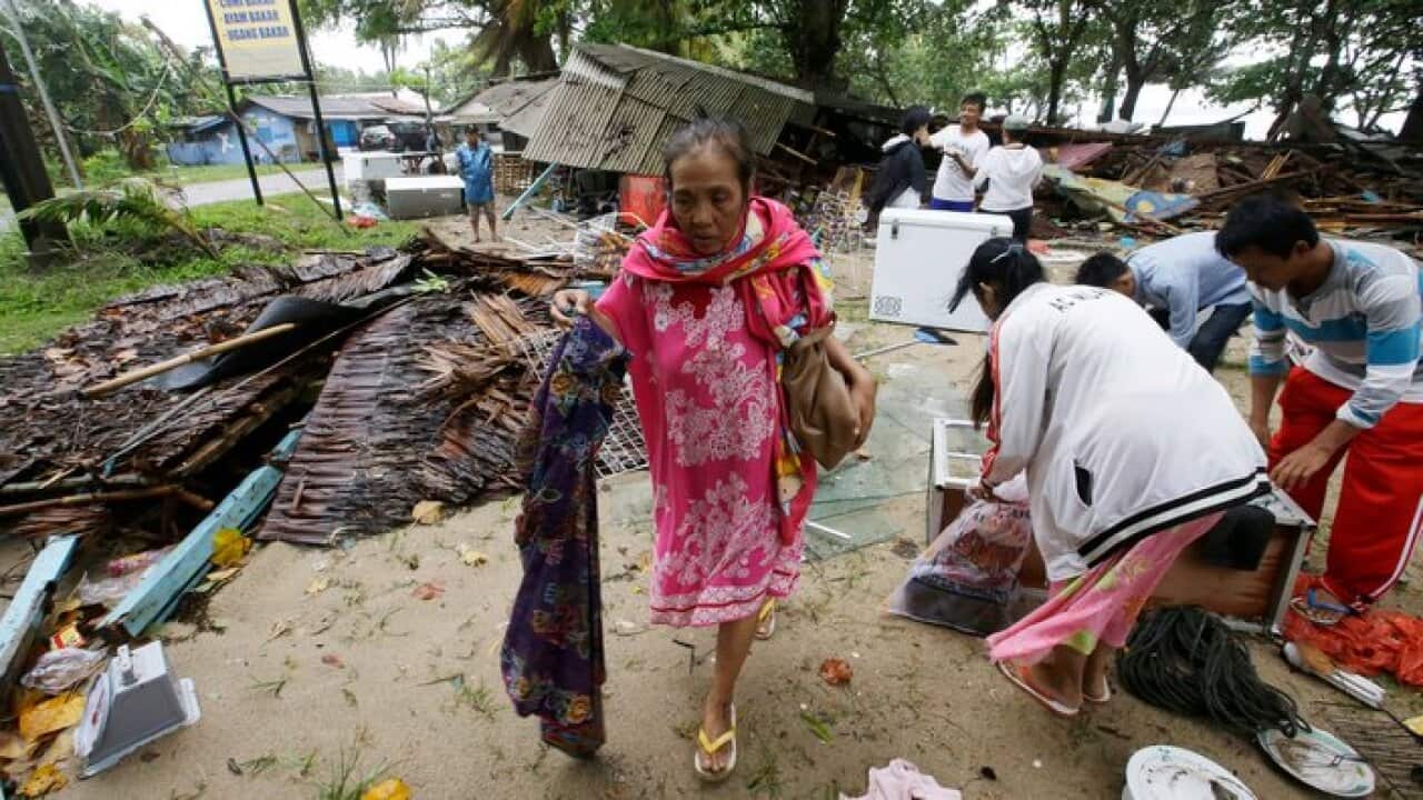 A women inspects her house which was damaged by a tsunami, in Carita, Indonesia, Sunday, Dec. 23, 2018.
