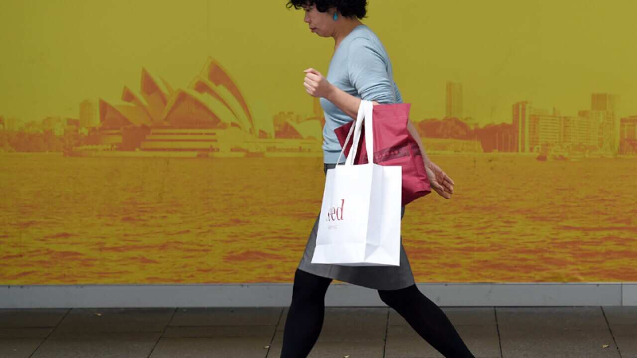 A shopper carries a bag from a retail store in Sydney