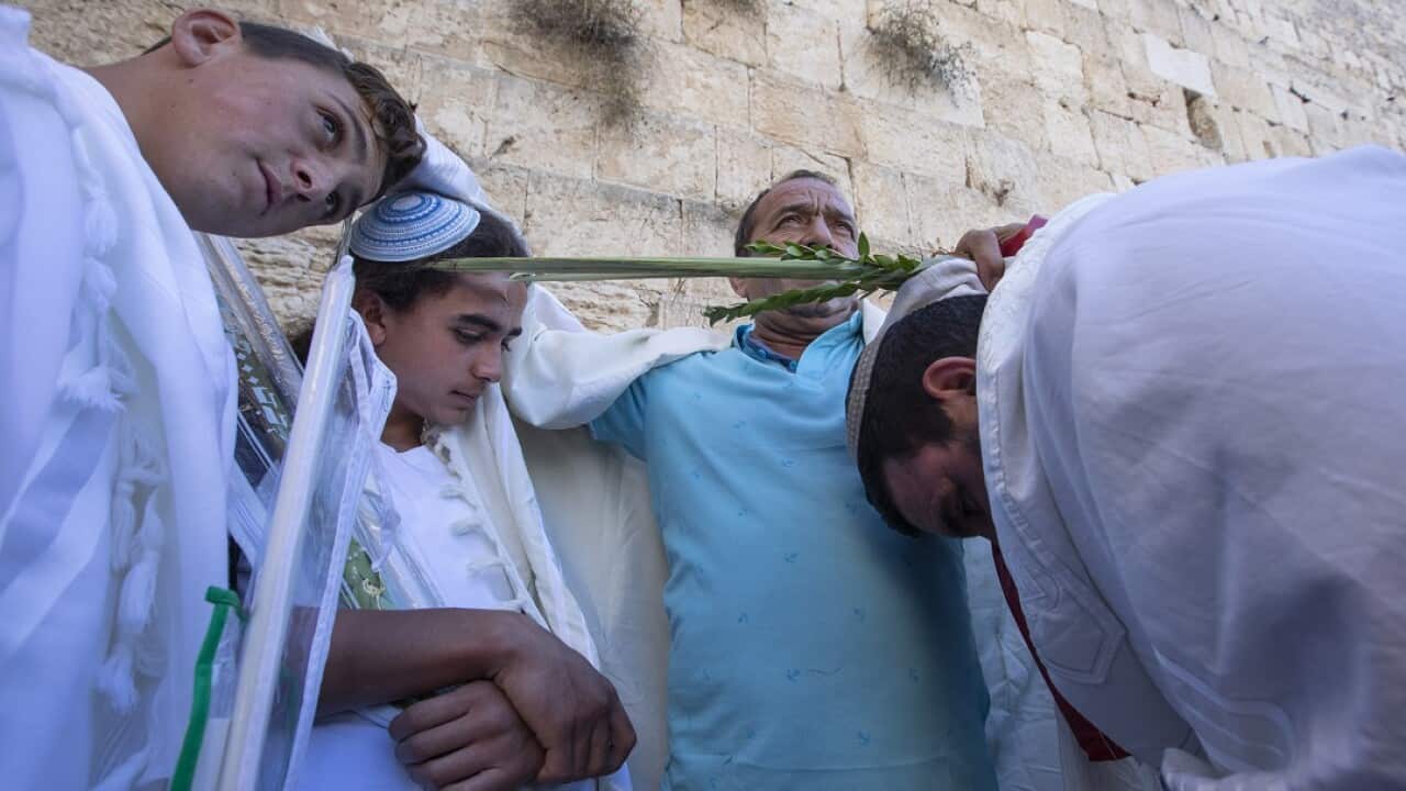 A Jewish man holds the heads of his sons as he blesses them during the 'Priestly Blessing,' or the Birkat Kohanimat the Western Wall.