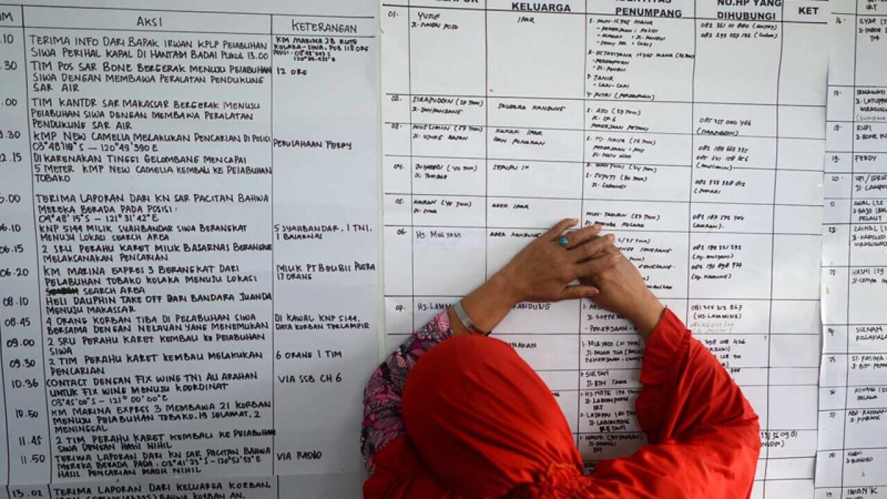 An Indonesian woman checks the passenger list of a capsized ferry