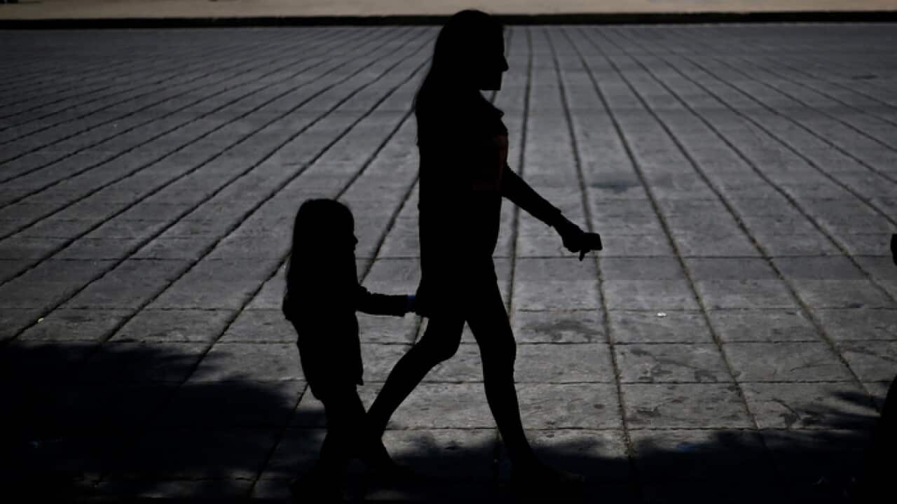 A woman and child walk during a march against human trafficking and slavery in Mexico City