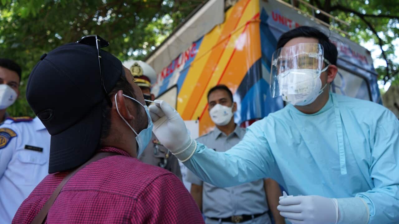 Traffic personnel supervise a health check and free antigen test for a driver who was at the Mallengkeri Terminal in Makassar City, Indonesia on July 28, 2021.