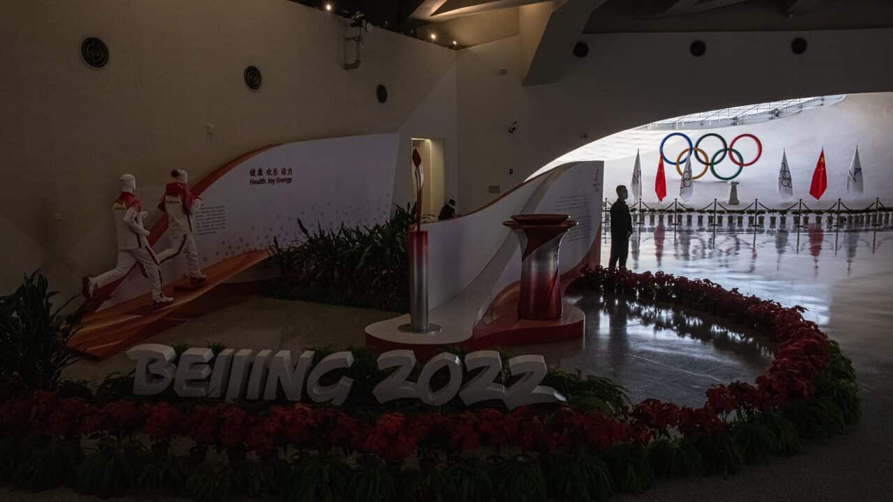 A security guard stands by the Olympic logo