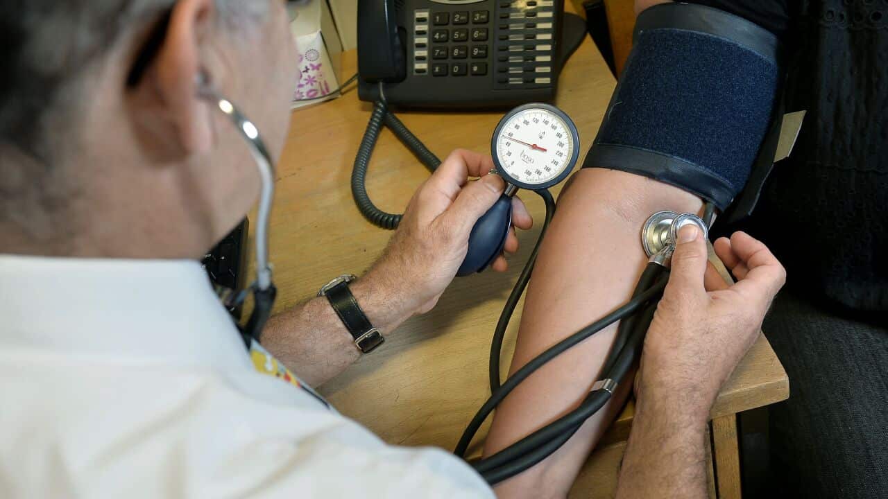 GP checking a patient's blood pressure.