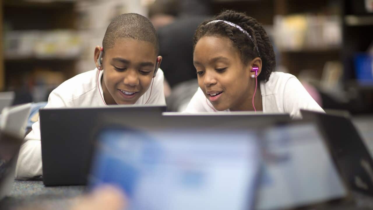 Fourth grade students work on laptops in class.