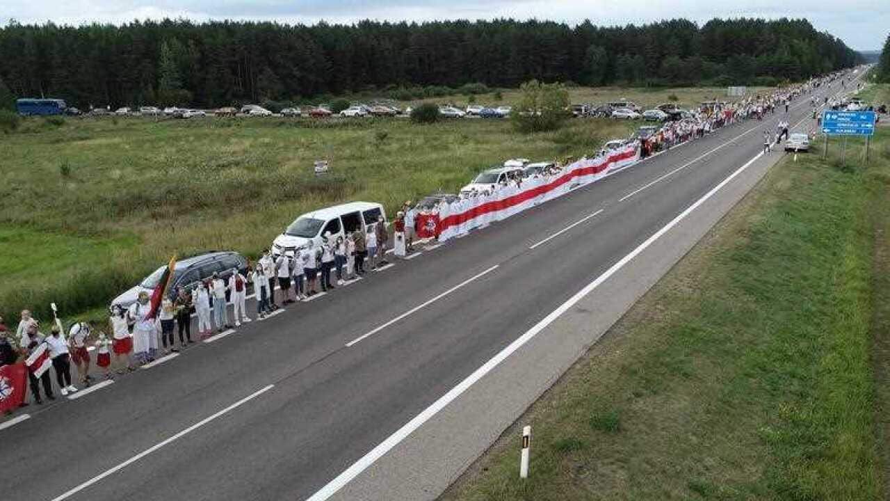 People hold hands as they participate in a human chain from Vilnius to the Belarusian border