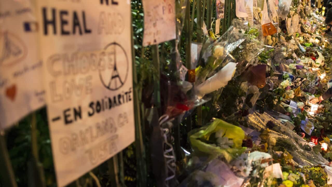 People lay flowers and candles across from the Bataclan concert venue.