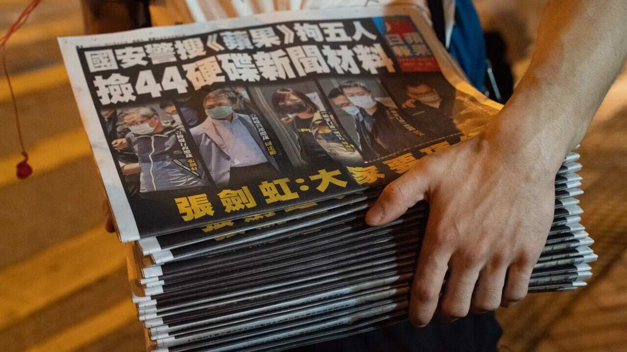 A man buys multiple copies of the latest Apple Daily newspaper on 18 June, 2021 in Hong Kong, China.