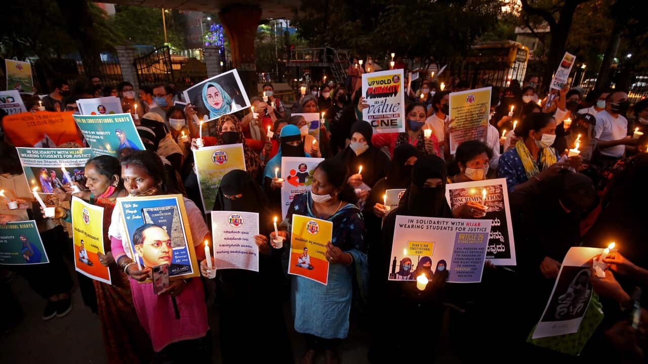 People hold placards and lit candles in solidarity with Muslim women wearing Hijabs