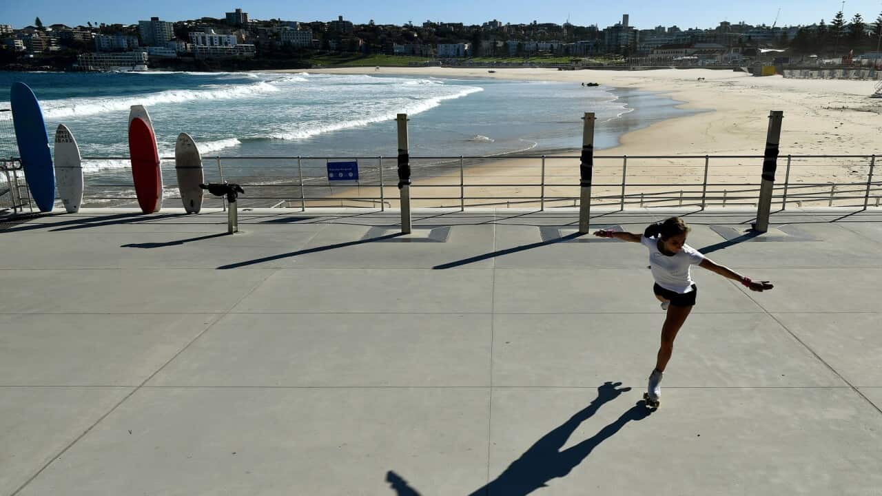 A woman roller skates in front of a closed Bondi Beach in Sydney