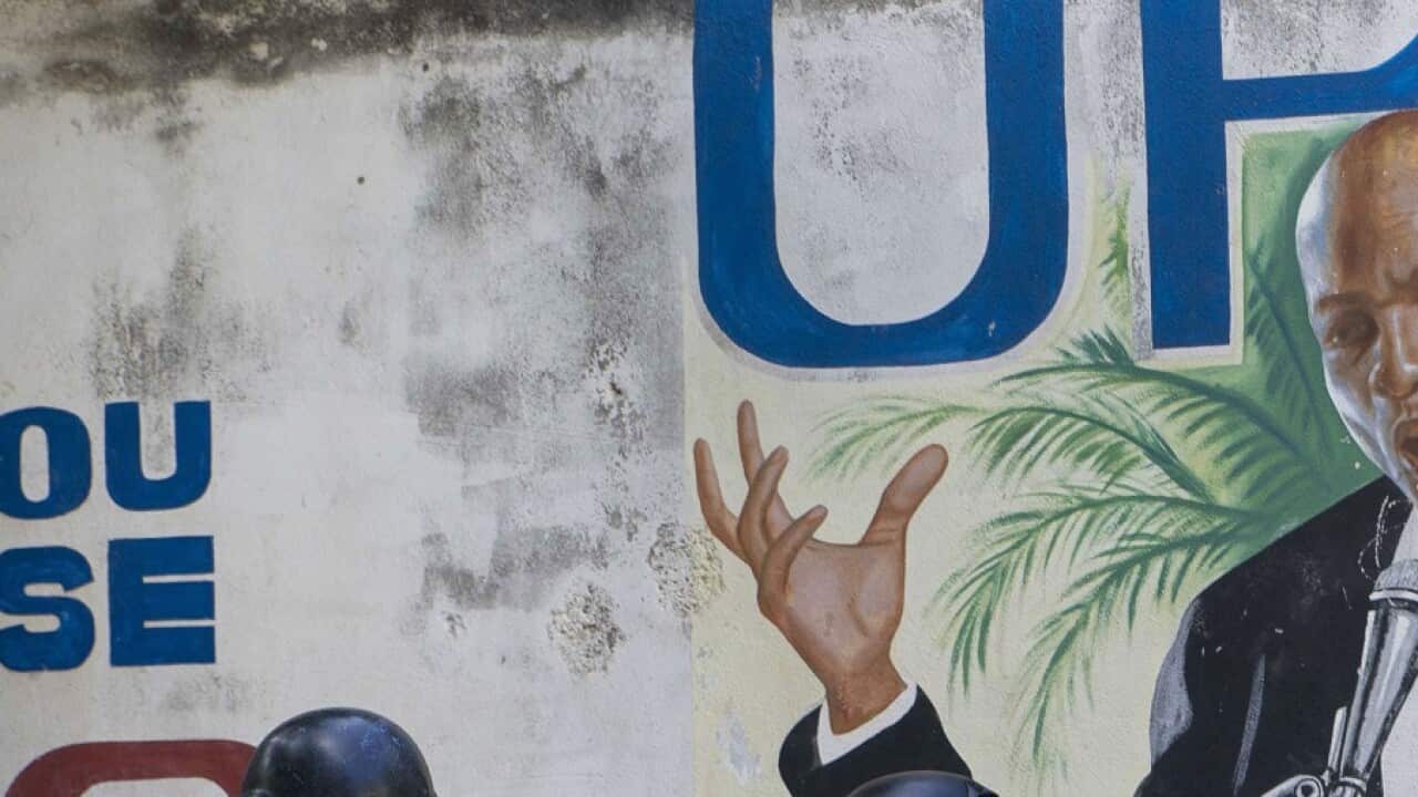 Police stand near a mural featuring Haitian President Jovenel Moise, near the leader’s residence where he was killed by gunmen in the early morning hours in Port-au-Prince, Haiti, Wednesday, July 7, 2021. (AP Photo/Joseph Odelyn)