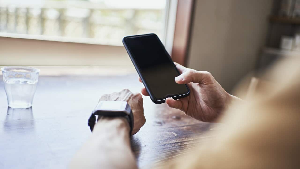 Man checking smartwatch and syncing smartwatch