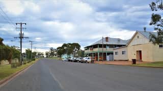 Fifield main street with a single pub and cars parked in a suburban landscape.