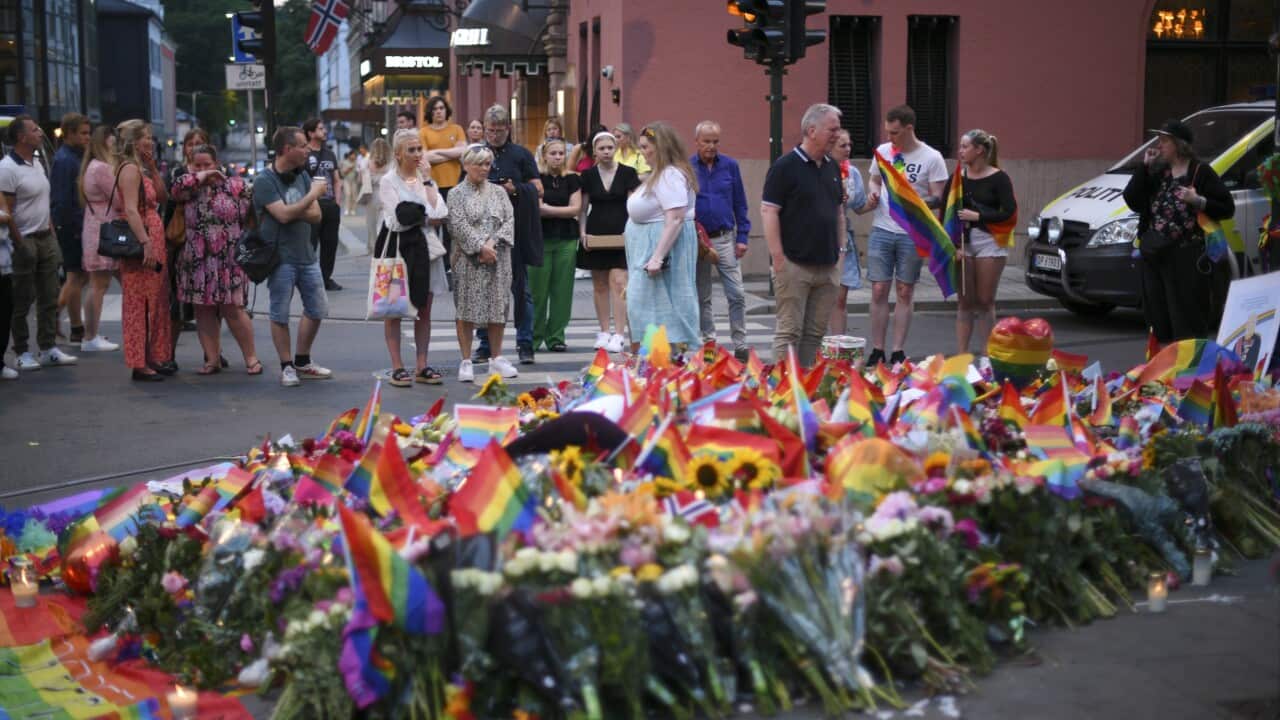 People lay flowers and rainbow flags in the aftermath of shootings in the center of Oslo, Norway, 25 June 2022.