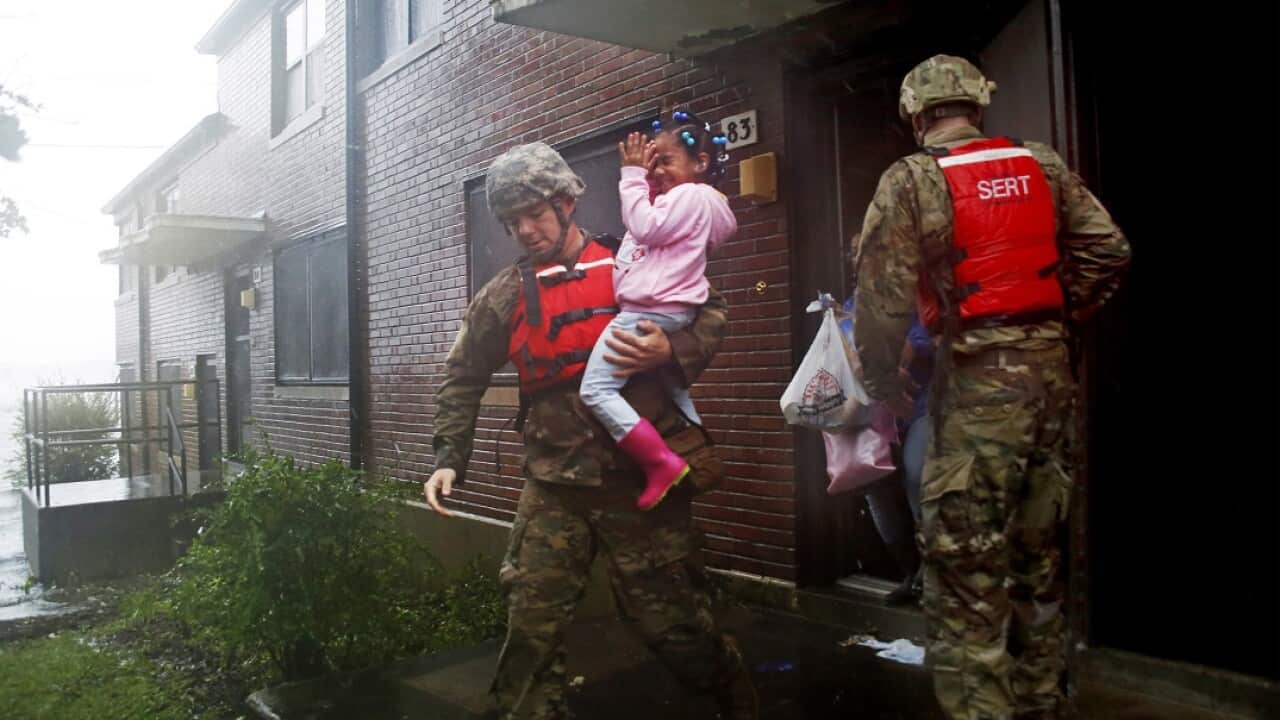 A rescue team from the North Carolina National Guard evacuates a family as the rising floodwaters from Hurricane Florence threatens their home.
