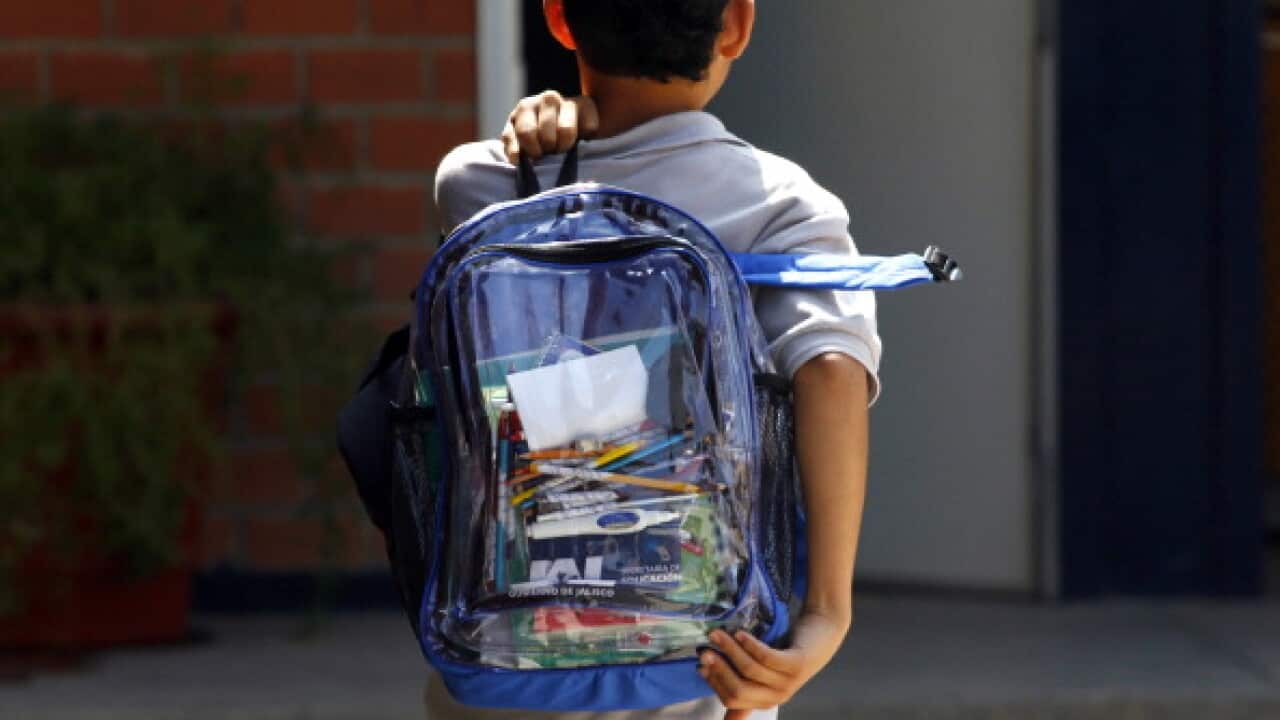 A secondary school student walks carrying a new transparent backpack in Guadalajara, Mexico on October 25, 2012.