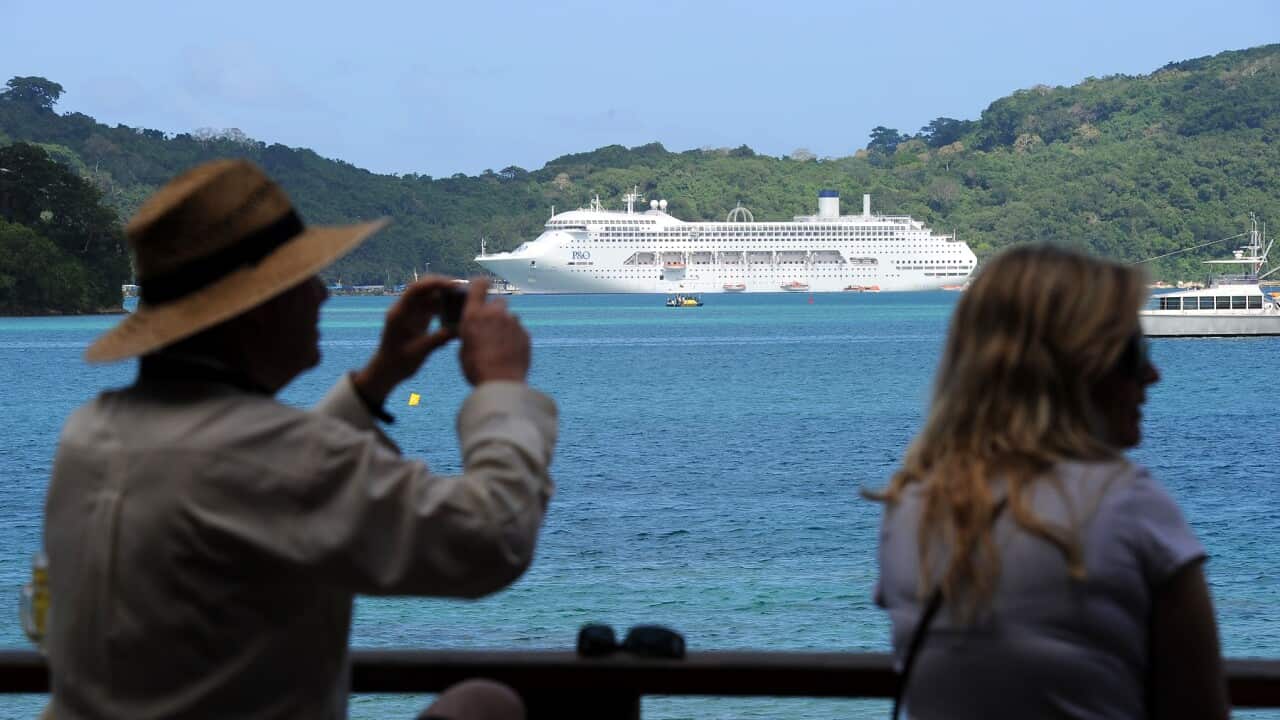 Tourists look on as the cruise ship 'Pac