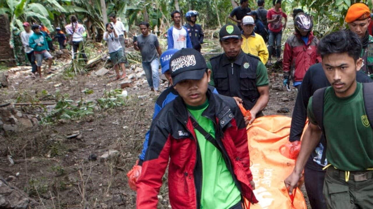 Indonesian volunteers carry a body after a tsunami on Anyer Beach in Karang Sugara village, Anyer, Banten, Indonesia, 24 December 2018 (AAP)
