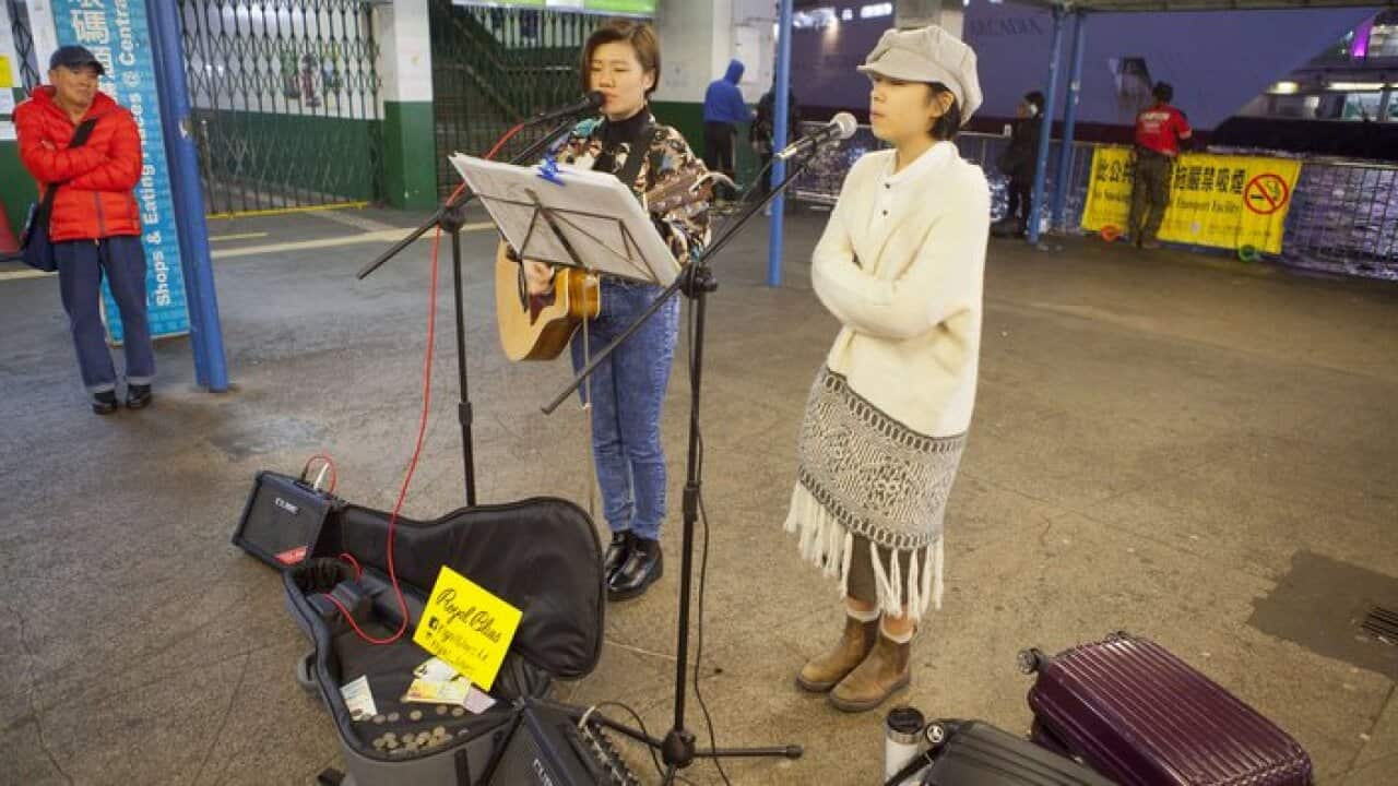 Street musicians perform at the Star Ferry Pier in Hong Kong