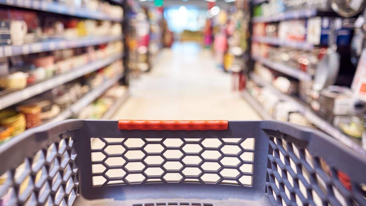 Abstract blurred photo of empty trolley in supermarket bokeh background. Empty shopping cart in supermarket