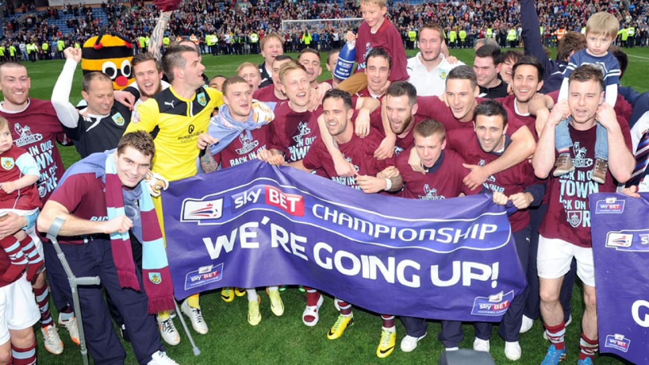 The Burnley team celebrates after winning promotion