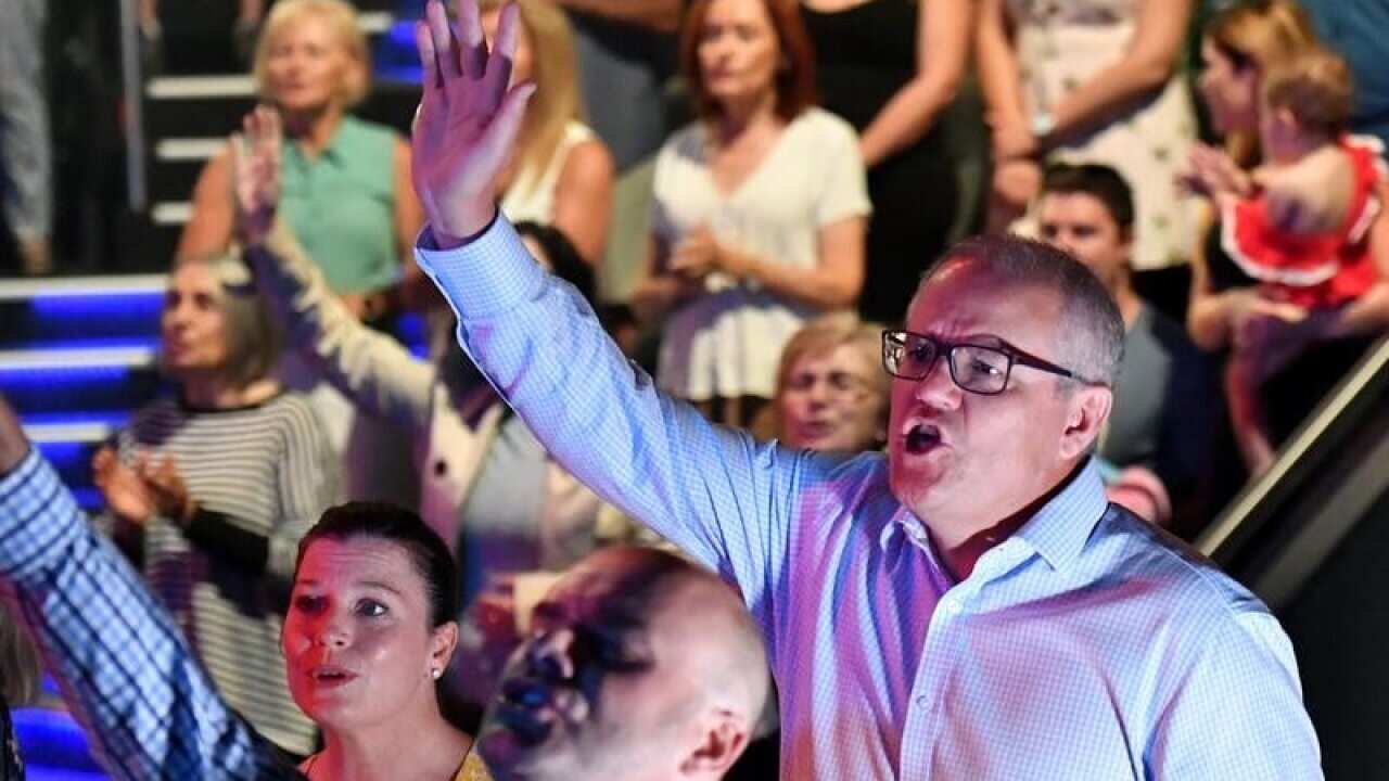 Scott Morrison and wife Jenny sing during an Easter Sunday service at their church in Sydney. The PM has always been open about his faith.