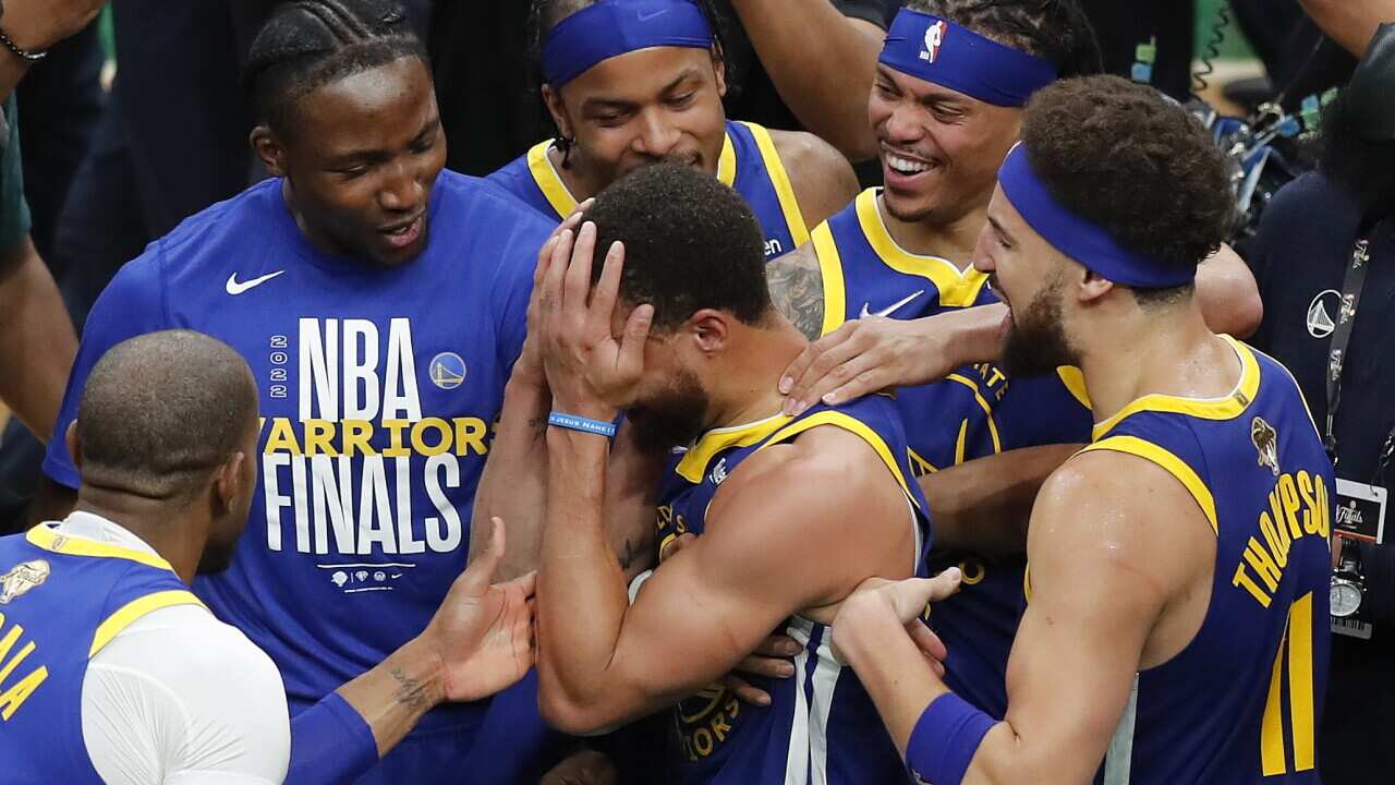 Golden State Warriors guard Stephen Curry, center, celebrates with teammates after beating the Boston Celtics in Game 6 to win basketball's NBA Finals championship, Thursday, June 16, 2022, in Boston. (AP Photo/Michael Dwyer)