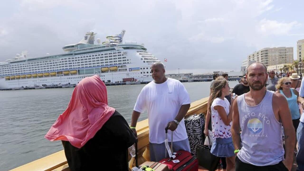 People lining up to get on a cruise ship.