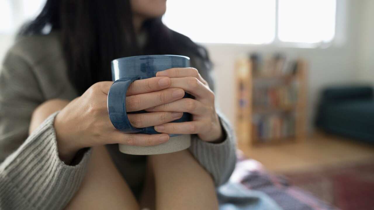 Close up woman drinking tea in bed