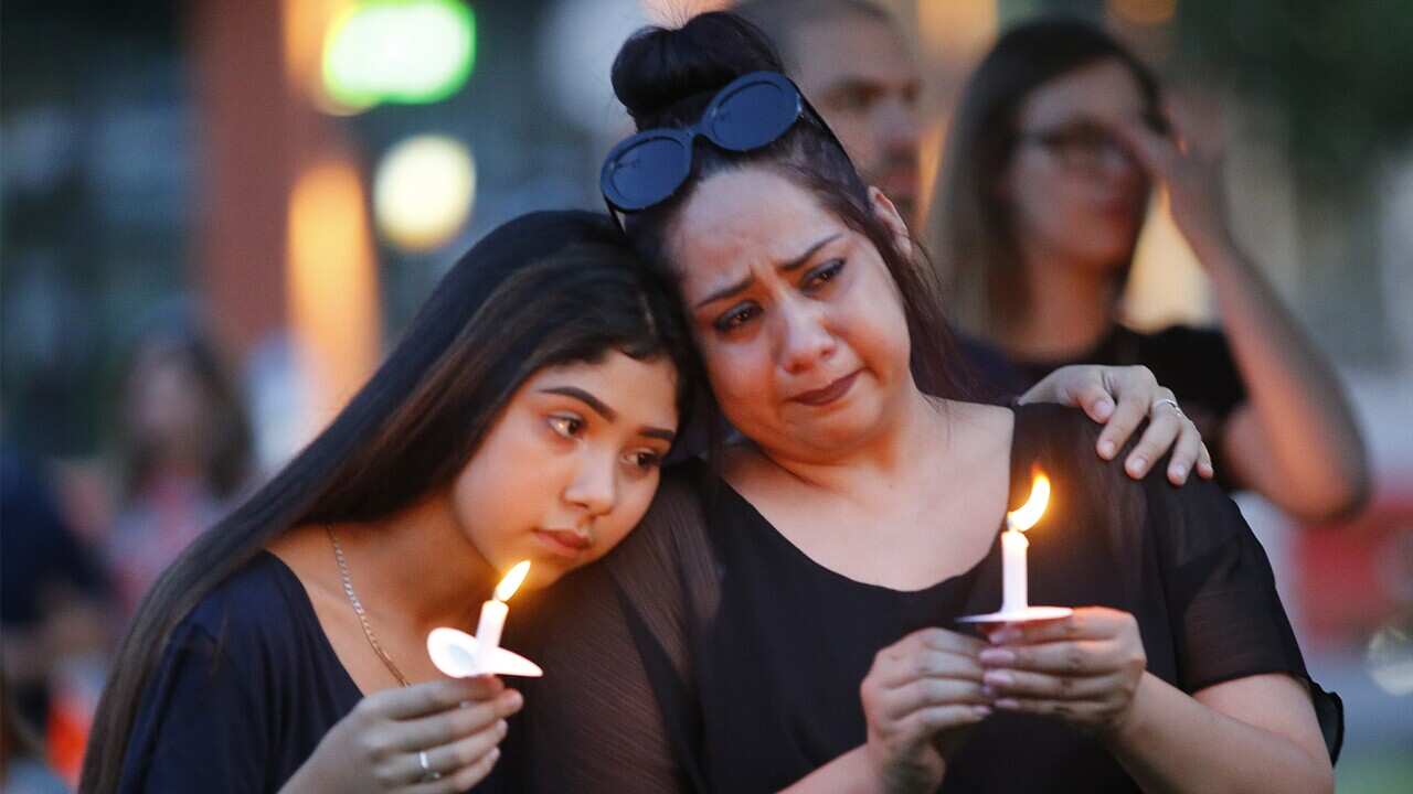 Former El Paso residents Monica Martinez (right) of McKinney and her daughter Tory, 15, during a candle light vigil.