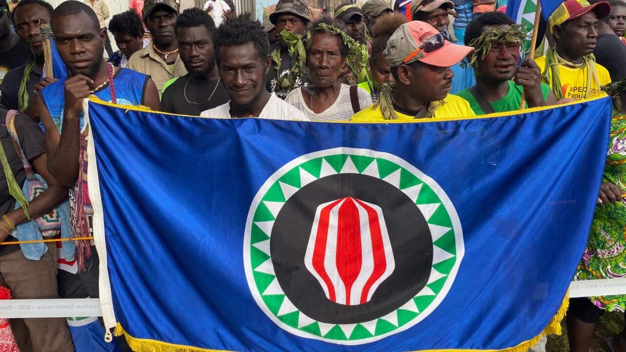 Voters proudly show off the flag of Bougainville, the symbol of the Autonomous Region of Bougainville in Papua New Guinea, as they head to cast their ballots.