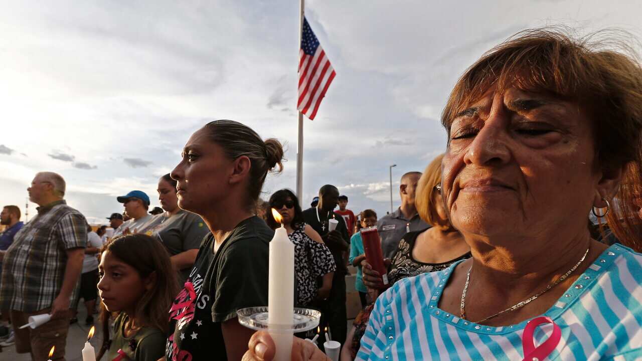 People hold candles at a vigil for the victims of the El Paso shooting.