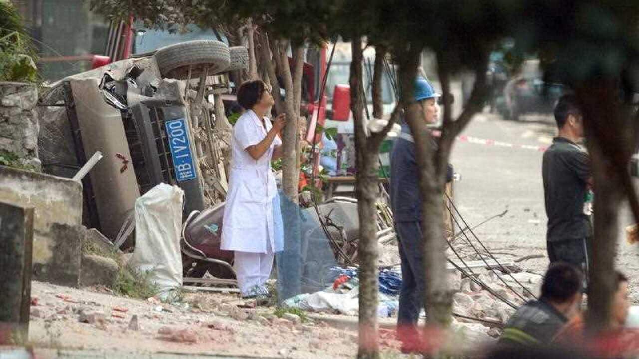 A car lies on its side in the aftermath of a parcel bomb explosion in the city of Liuzhou.