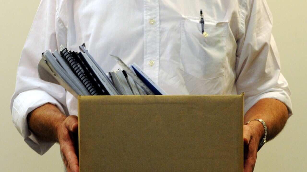 An office worker holds a box of office supplies