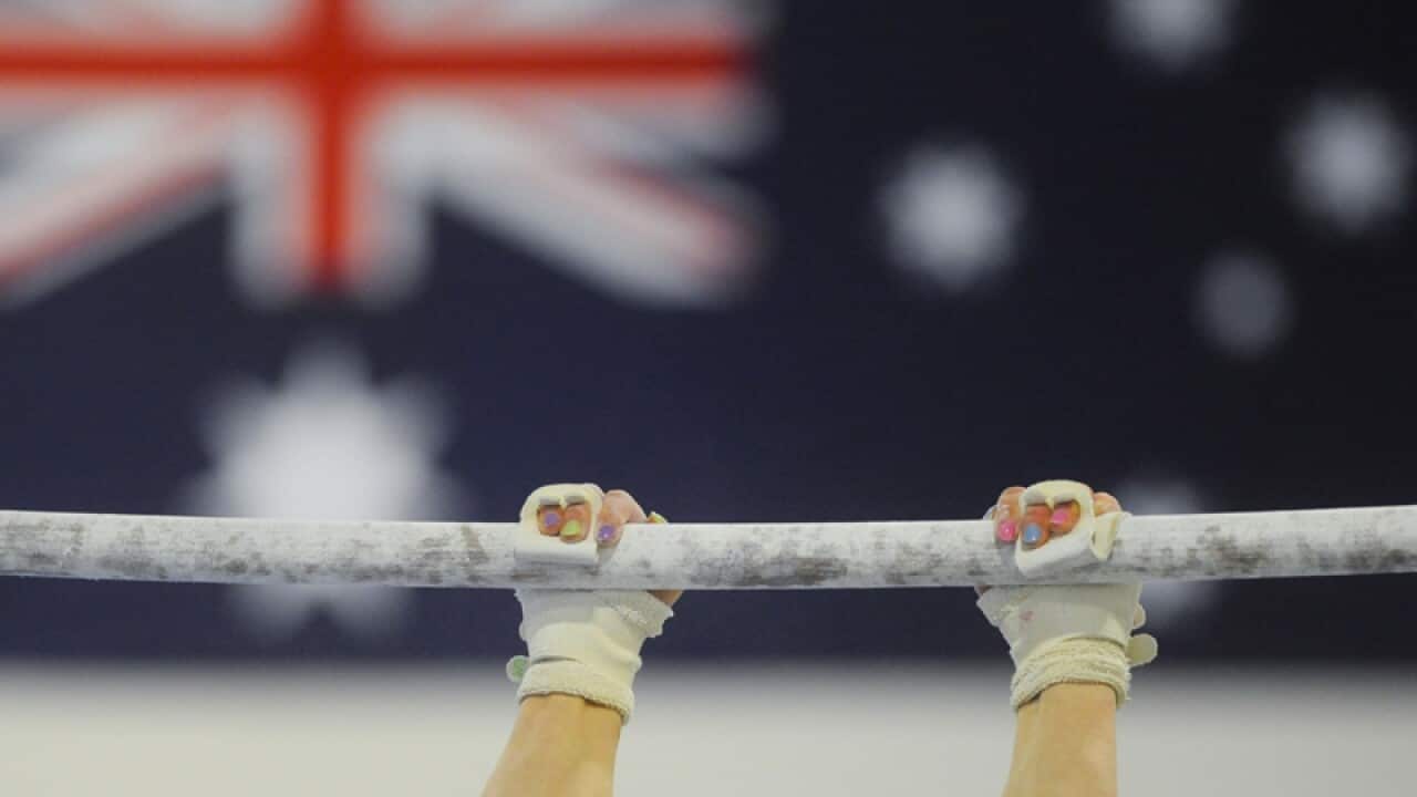 A gymnast practises on the uneven bars at a gymnastic centre