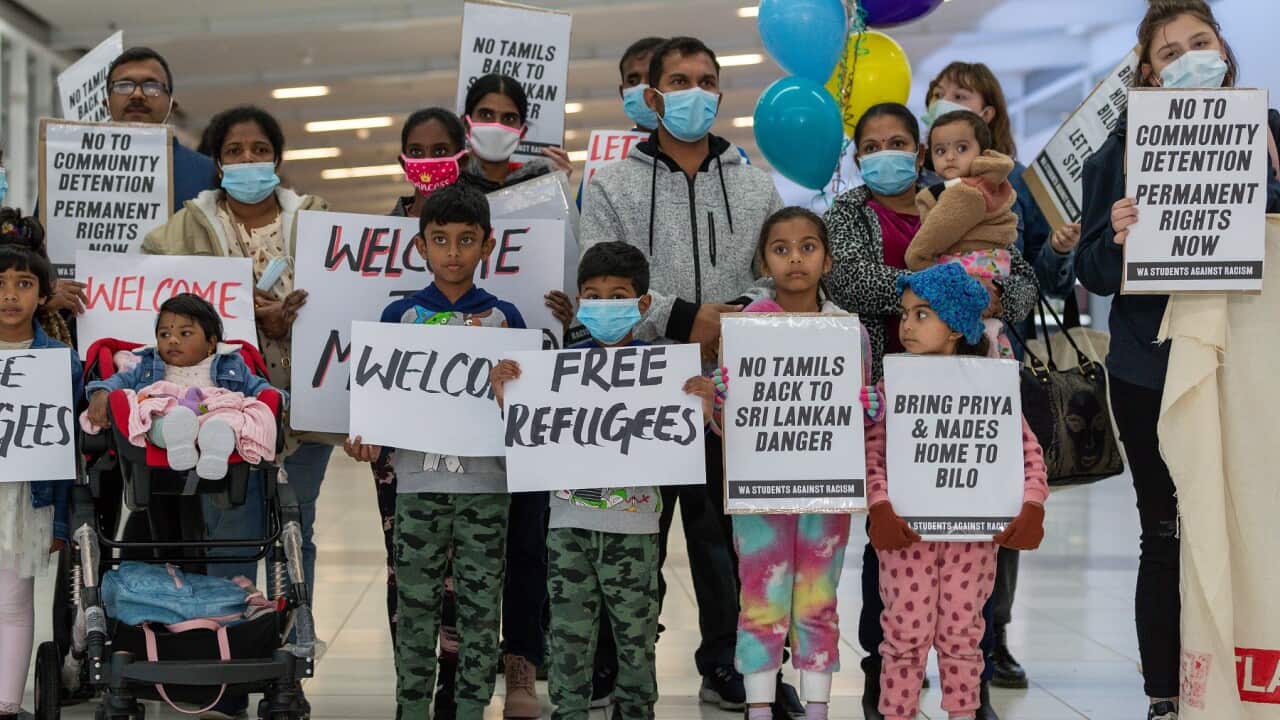 Supporters of the Murugappan family holding signs at Perth airport