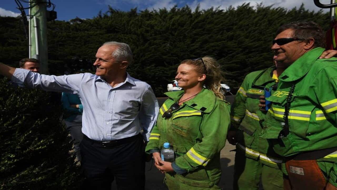 Malcolm Turnbull poses for a photograph with firefighters