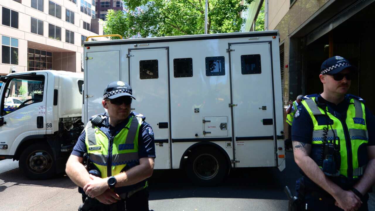 Police officers block the street in front of the Magistrates Court