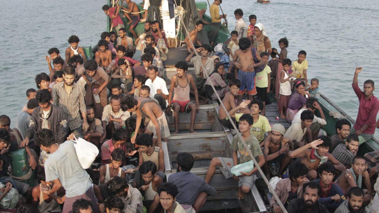 Migrants wait to be rescued by fishermen on their boat