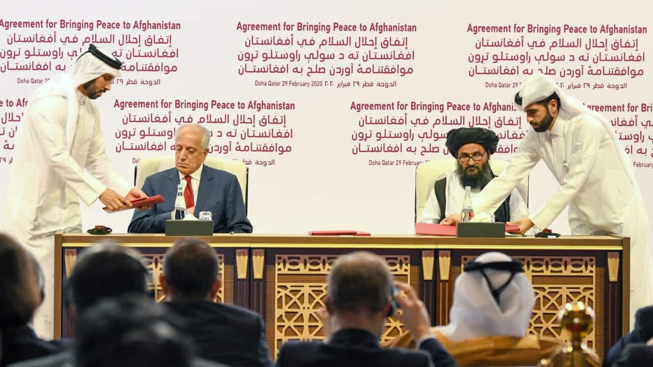 US Special Representative for Afghanistan Reconciliation Zalmay Khalilzad (2-L) and Taliban co-founder Mullah Abdul Ghani Baradar sign in Doha in 2020.