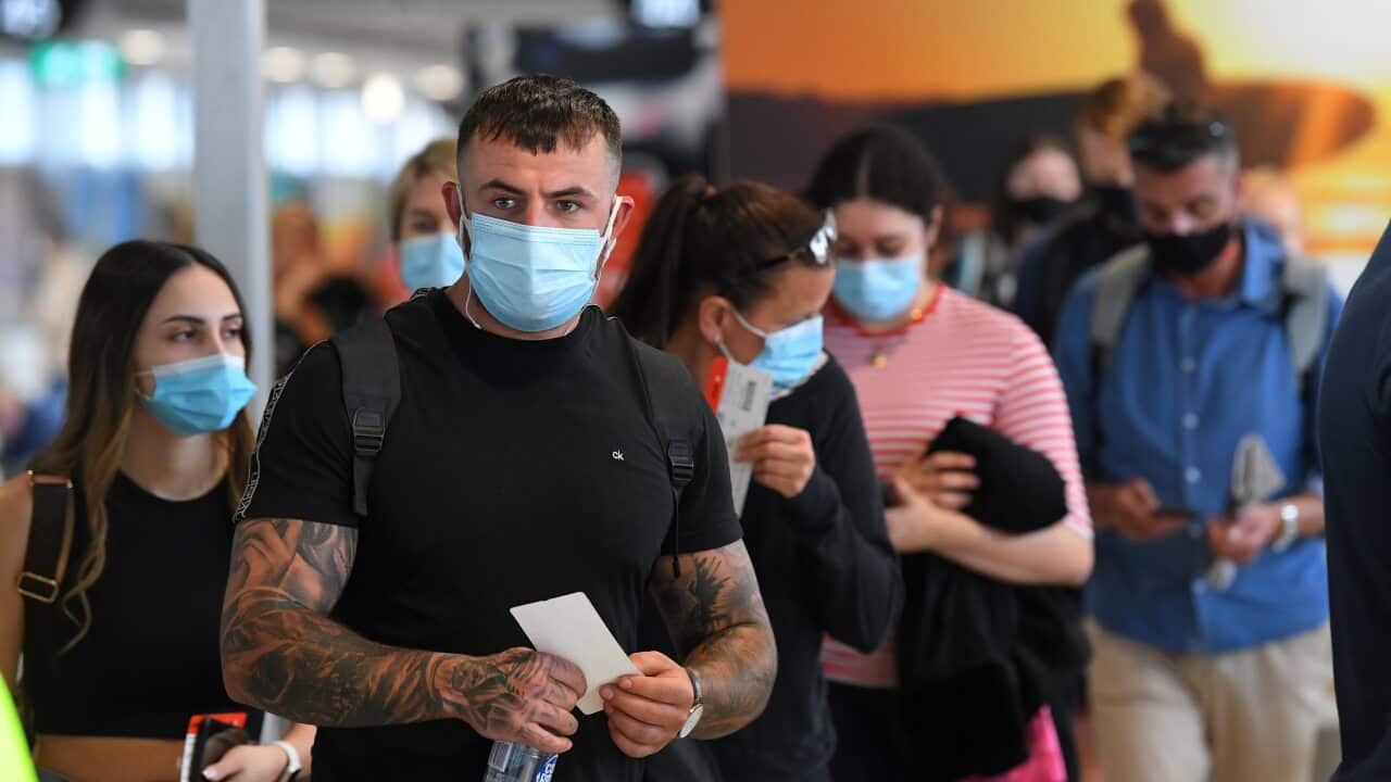 People wearing face masks are seen waiting to board a flight to Sydney at Melbourne.