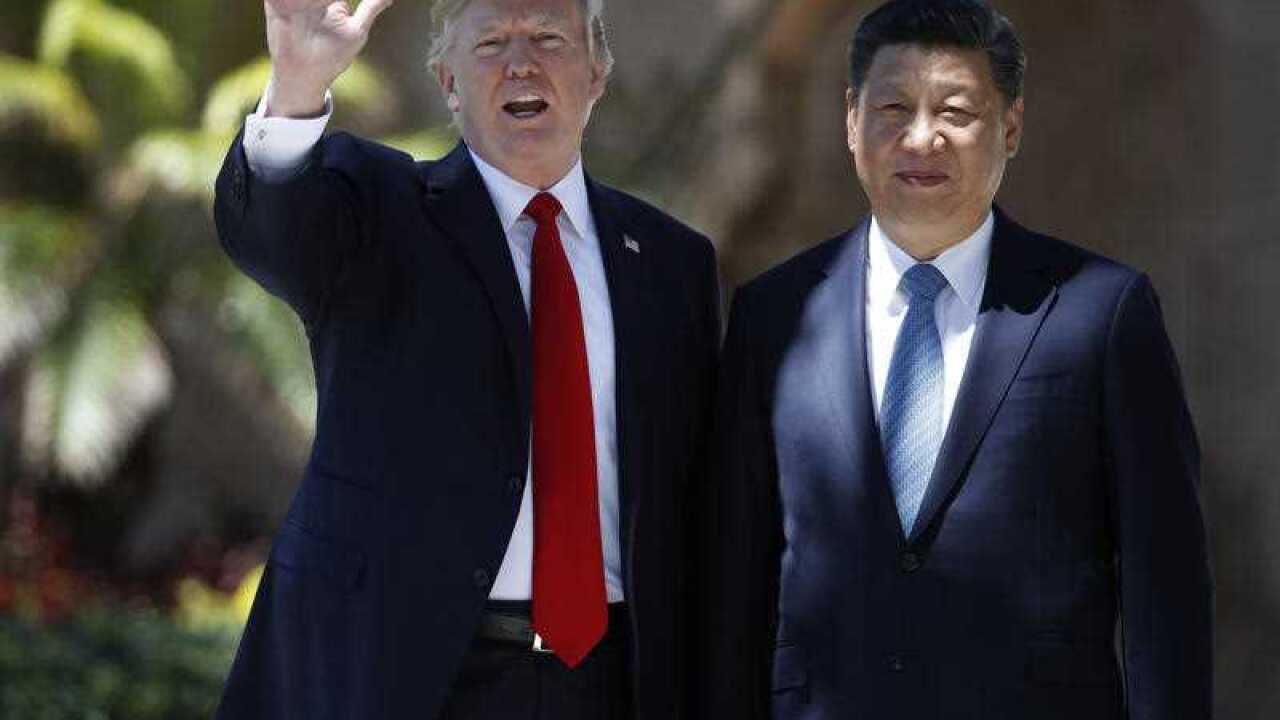 President Donald Trump and Chinese President Xi Jinping pause for photographs at Mar-a-Lago, in Palm Beach