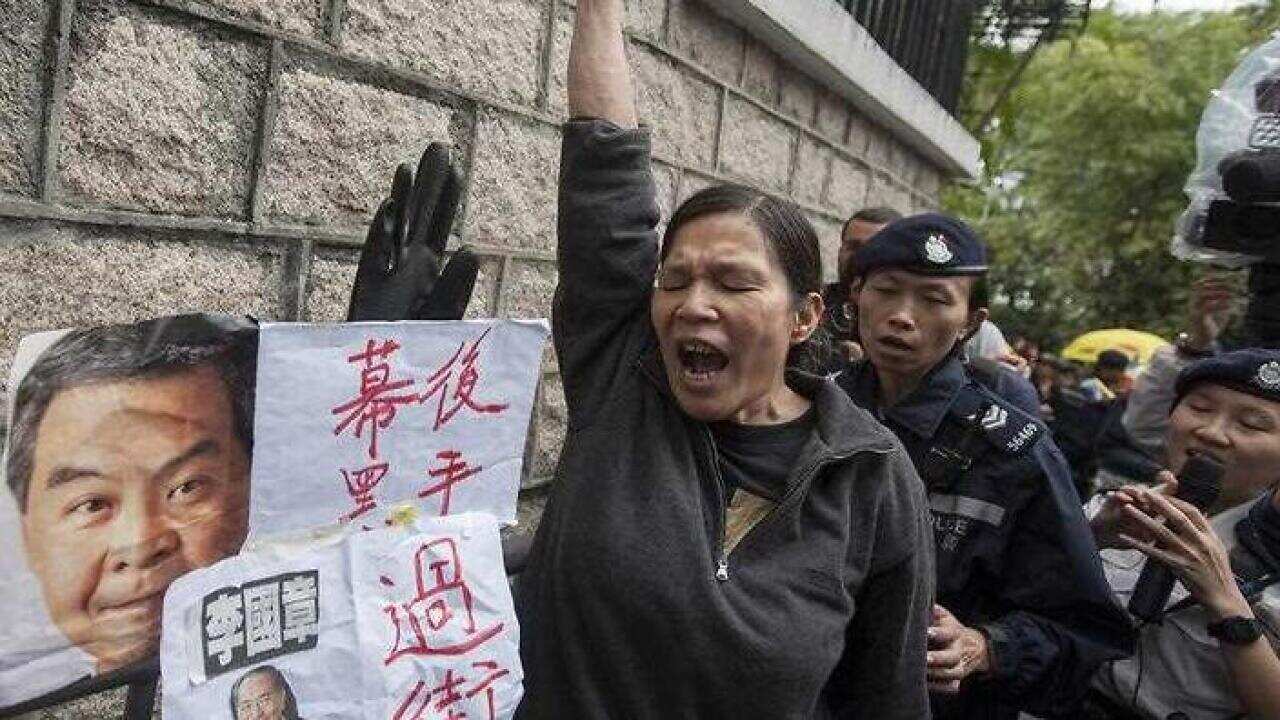 A protesters shouts next to pictures of Hong Kong's Chief Ecexutive Leung Chun-ying and Hong Kong University President Arthur Li, as Hong Kong University students, faculty and alumni protest growing fears of loss of academic freedom and institutional aut